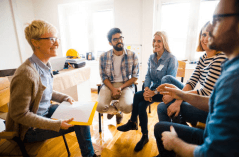 a group of people sitting in chairs in a talking