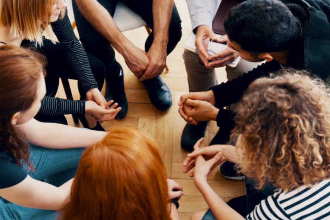 close-up of group of people leaning into a circle